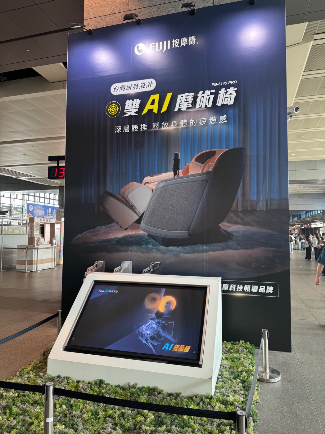 A Taichung railway station display advertising a dual-AI massage chair