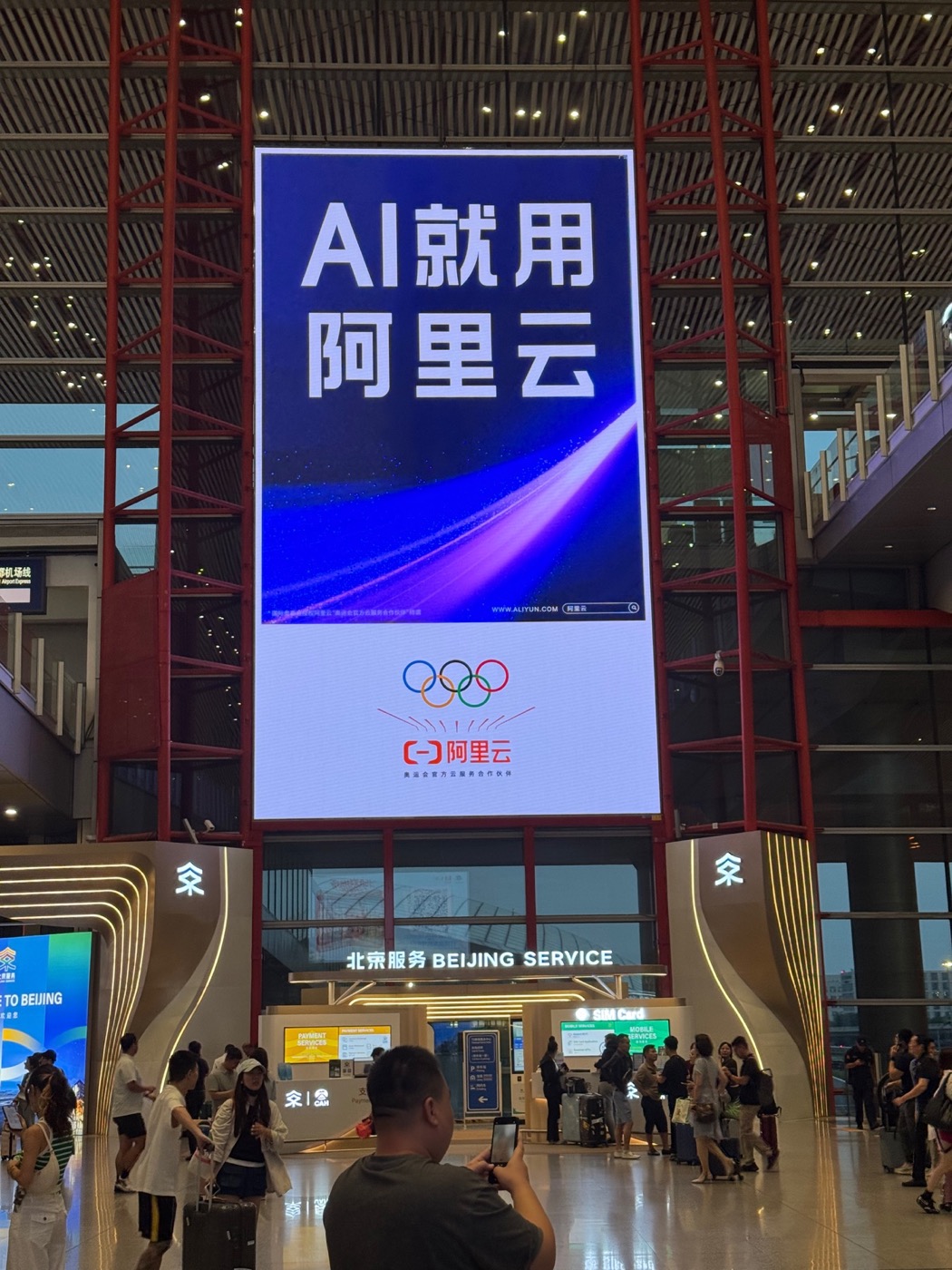 An Alibaba Cloud advertisement at Beijing Capital International Airport reading AI means Alibaba Cloud